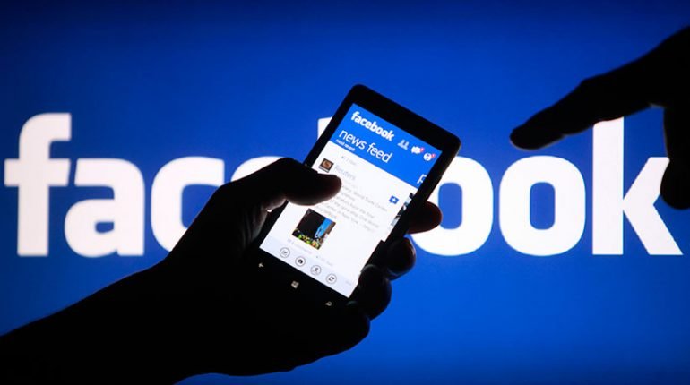 A smartphone user shows Facebook application on his mobile device